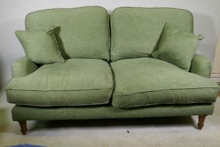 A Howard style two seater settee in green linen upholstery, 170cm wide