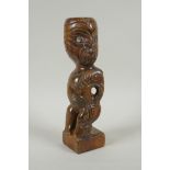 A Maori carved wood Tiki figure with abalone eyes, 28cm high