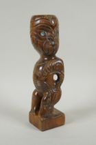 A Maori carved wood Tiki figure with abalone eyes, 28cm high