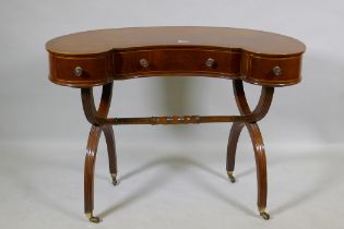 A Victorian inlaid mahogany kidney shaped desk/dressing table, raised on reeded cross frame end