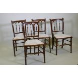 Four C19th beechwood and walnut side chairs with Gothic style backs, raised on turned tapering