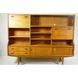 A mid century teak side cabinet with sliding glass doors and open shelves over two drawers and