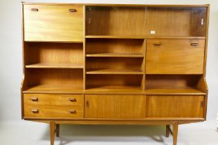 A mid century teak side cabinet with sliding glass doors and open shelves over two drawers and