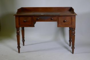 Early C19th mahogany kneehole desk of three drawers, with three quarter gallery top, raised on