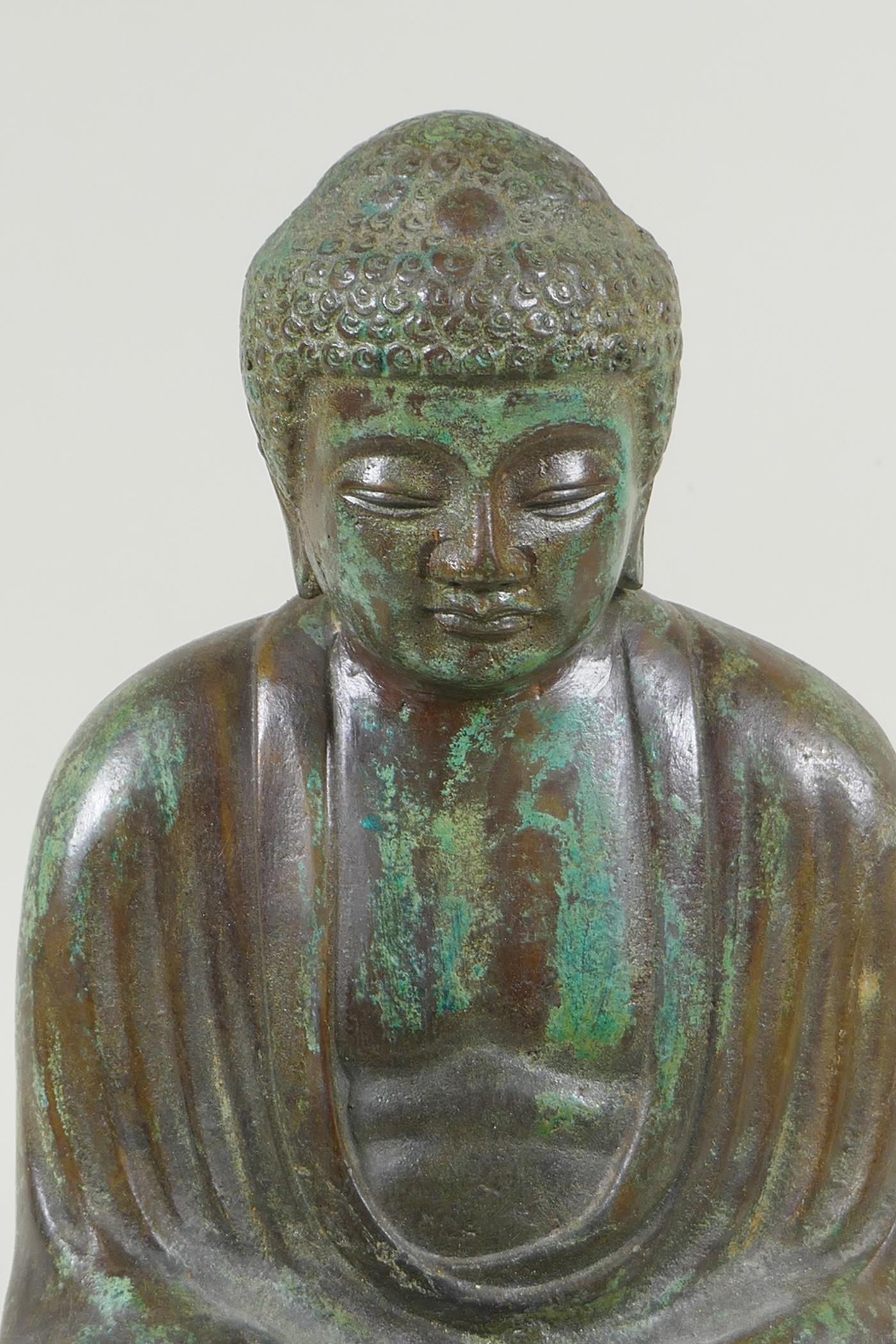 A Chinese patinated bronze figure of Buddha seated in meditation, on a carved hardwood stand, 31cm - Image 2 of 4