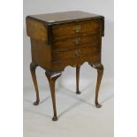 An early C20th Georgian style walnut work table, with drop flaps and three drawers, raised on