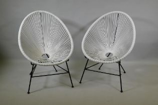 A pair of white rattan style Acapulco garden chairs
