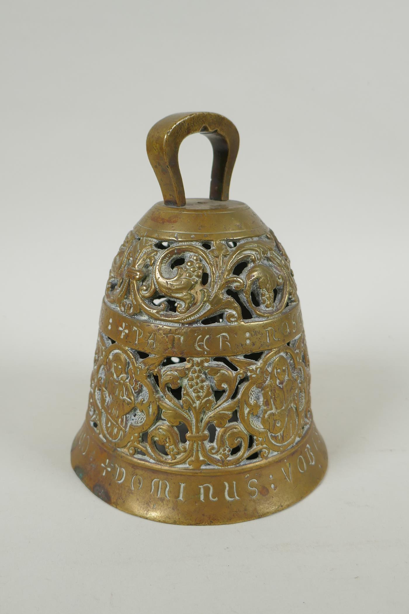 An antique pierced bronze prayer bell decorated with depictions of angelic musicians and Catholic