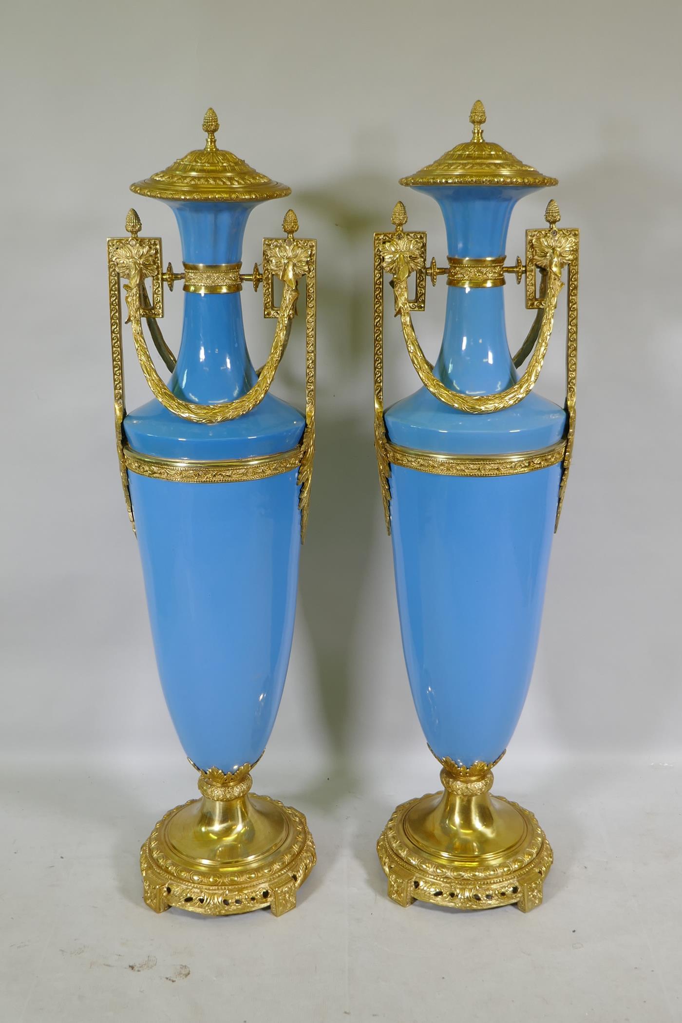 A large pair of Sevres blue style ceramic urns with ormolu mounts, 135cm high