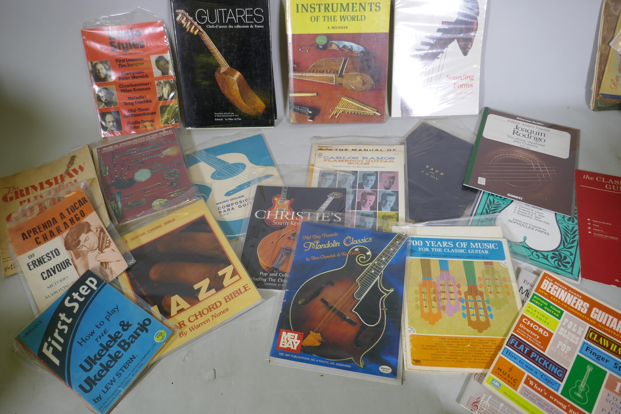 A collection of books, musical instruments, folk and African, guitars and instruction manuals
