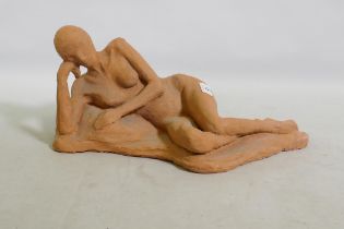 A terracotta sculpture of a reclining nude, inscribed MJ 94, 46 x 21cm