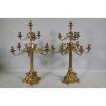 A pair of ormolu brass nine branch candelabra with ram's mask decoration, raised on fluted columns