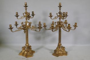 A pair of ormolu brass nine branch candelabra with ram's mask decoration, raised on fluted columns