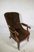 A Victorian mahogany framed open arm chair with button back and carved scroll arms, raised on turned