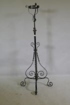 A Victorian wrought iron and brass telescopic standard lamp base with oil lamp basket, 140cm high,