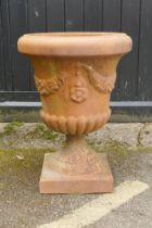 A terracotta garden urn, with floral swag decoration, 67cm high x 48cm diameter