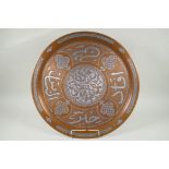 An Islamic silver overlaid copper tray with caligraphic script decoration, 55cm diameter