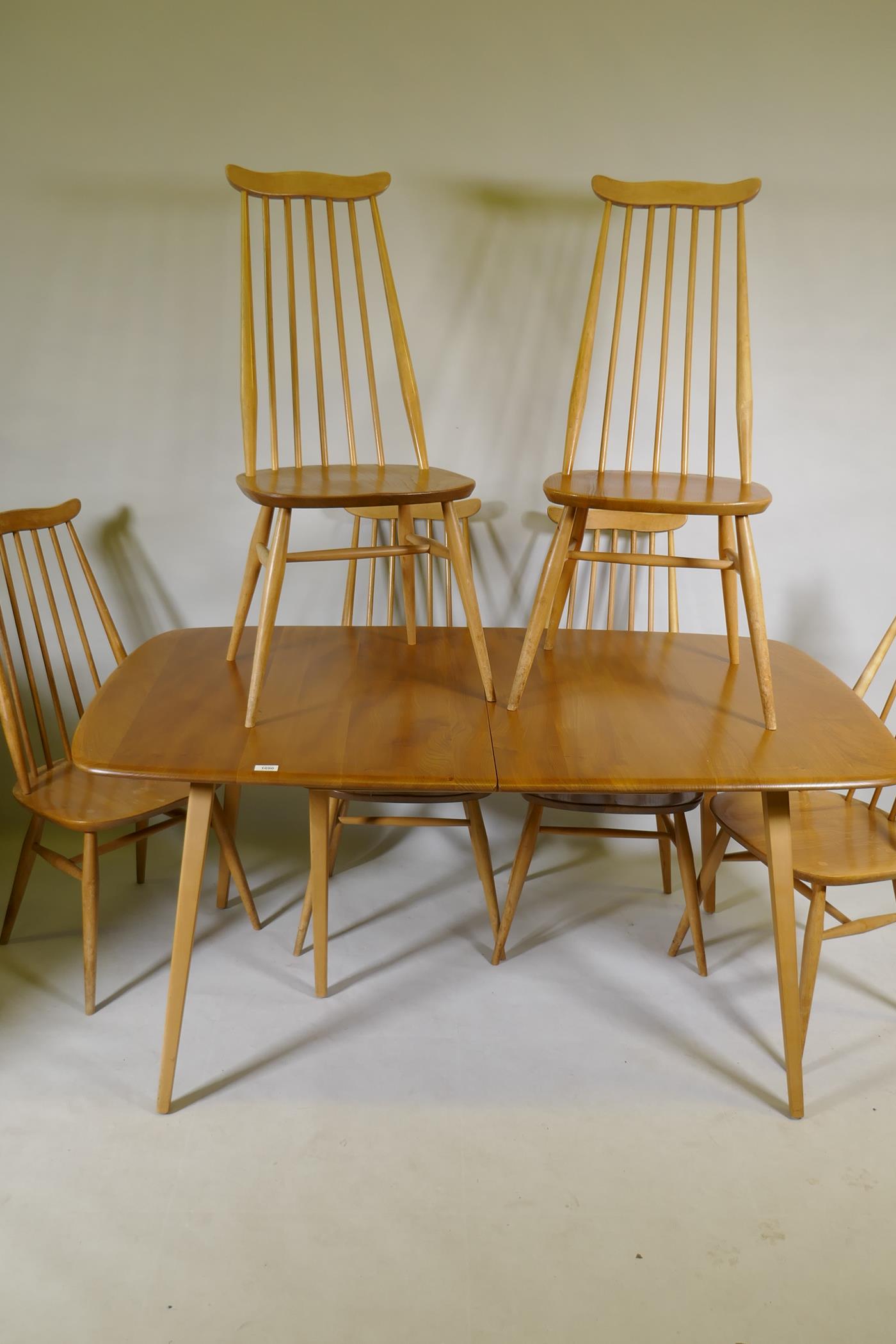 An Ercol Grand Windsor blond elm and beech extending dining table Model 444, and six matching Ercol