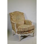 An C18th style French carved and painted beechwood framed arm chair with tapestry covers