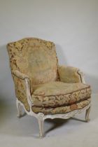An C18th style French carved and painted beechwood framed arm chair with tapestry covers