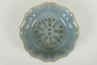 A Chinese celadon crackleware bowl of lobed form, with a gilt metal rim and chased character