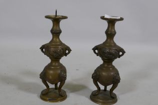 A pair of Oriental brass pricket candlesticks, raised on tripod supports, 20cm high