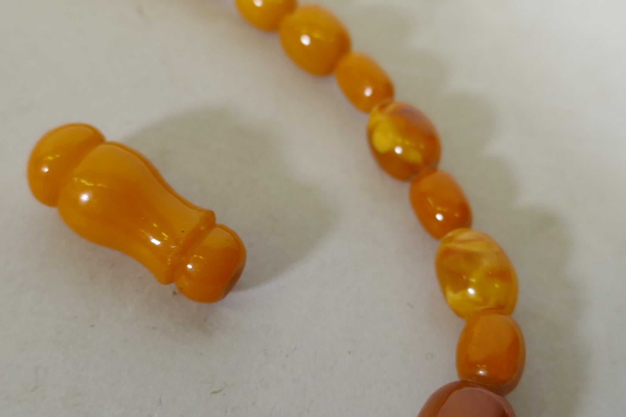 A vintage amber bead necklace and two loose beads, 24g, 36cm long - Image 3 of 3