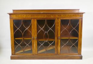 A Victorian mahogany bookcase, with inlaid frieze over three glazed doors, with five barred