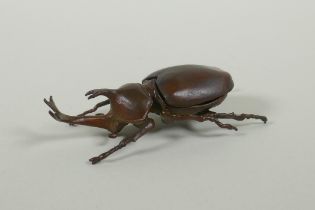 A Japanese style bronze okimono rhinoceros beetle, 9cm long