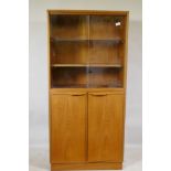 A mid century teak cabinet, with sliding glass doors over two cupboards, 69 x 36 x 144cm