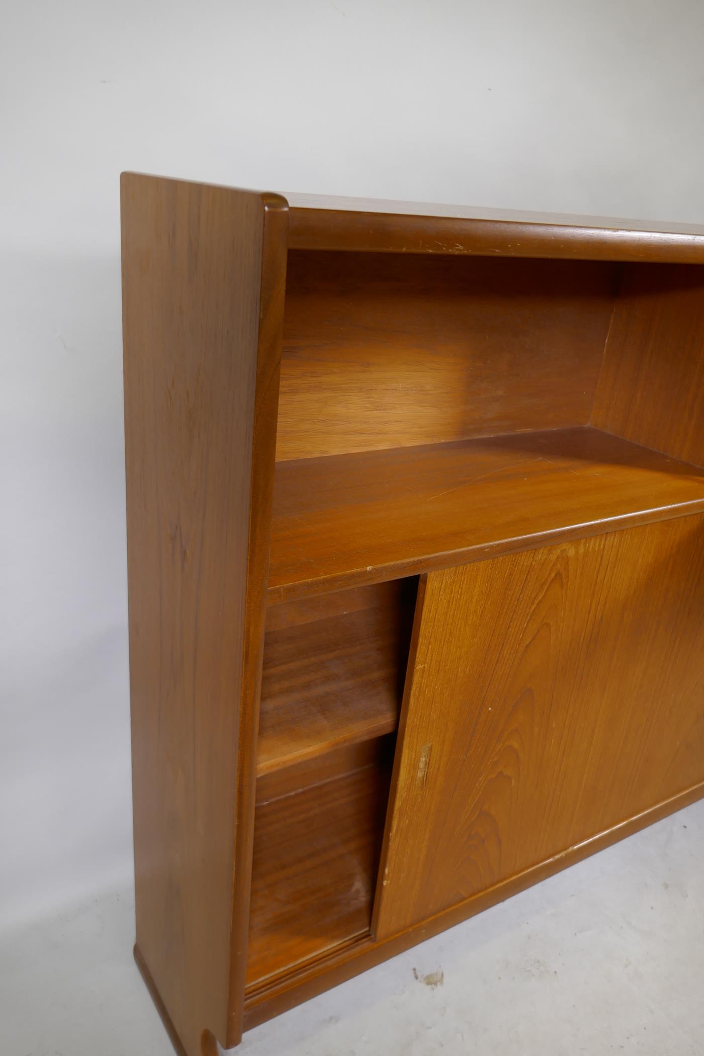 A mid century Nathan teak bookcase with open shelf and fall front over two sliding doors, raised - Image 3 of 3