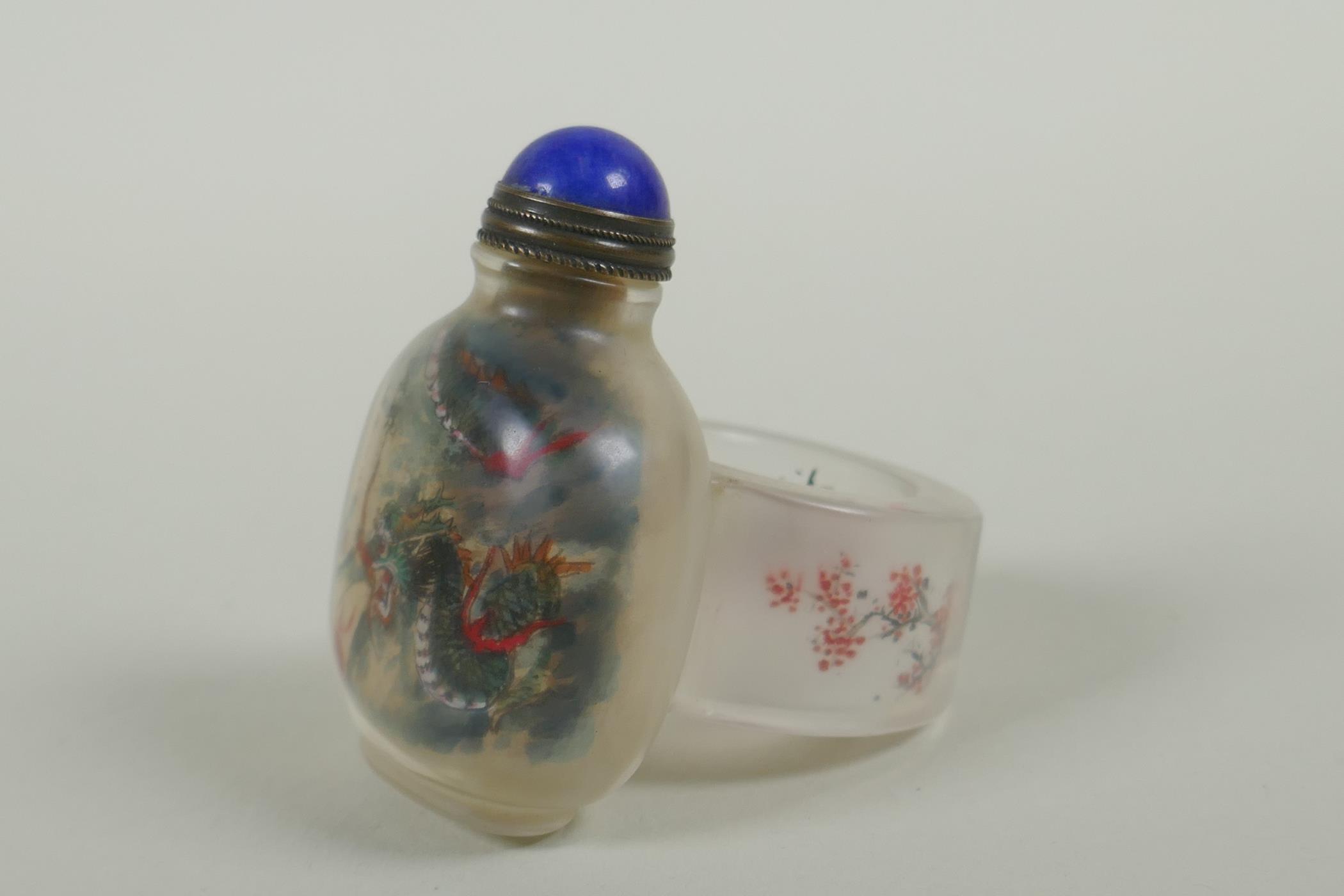 A Chinese reverse decorated glass snuff bottle on a ring, decorated with a green dragon and a red - Image 3 of 4