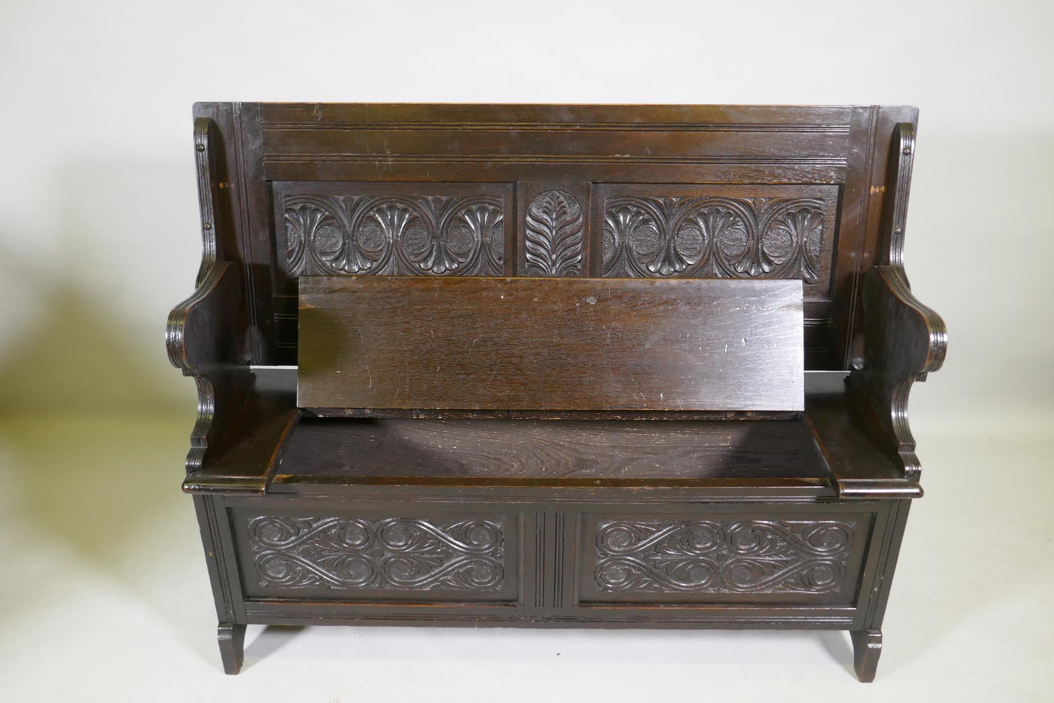 A Victorian oak monk's bench, with two panel fold over top, lift up seat and panelled front with - Image 2 of 3