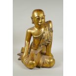 A carved and gilt Thai figure of a seated Buddha, the robes set with decorative stones, 40cm high