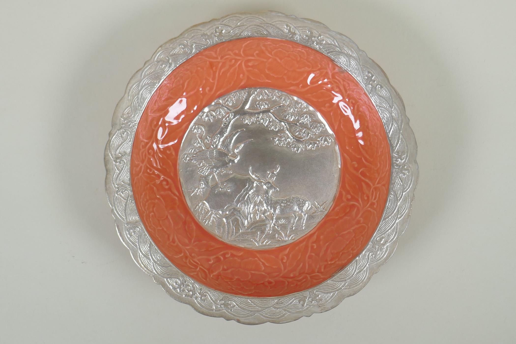 A Chinese salmon pink and silver glazed porcelain dish with lobed rim, with raised deer and crane