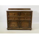A Jacobean style oak cabinet, the top drawer with fold down front over a single drawer and two