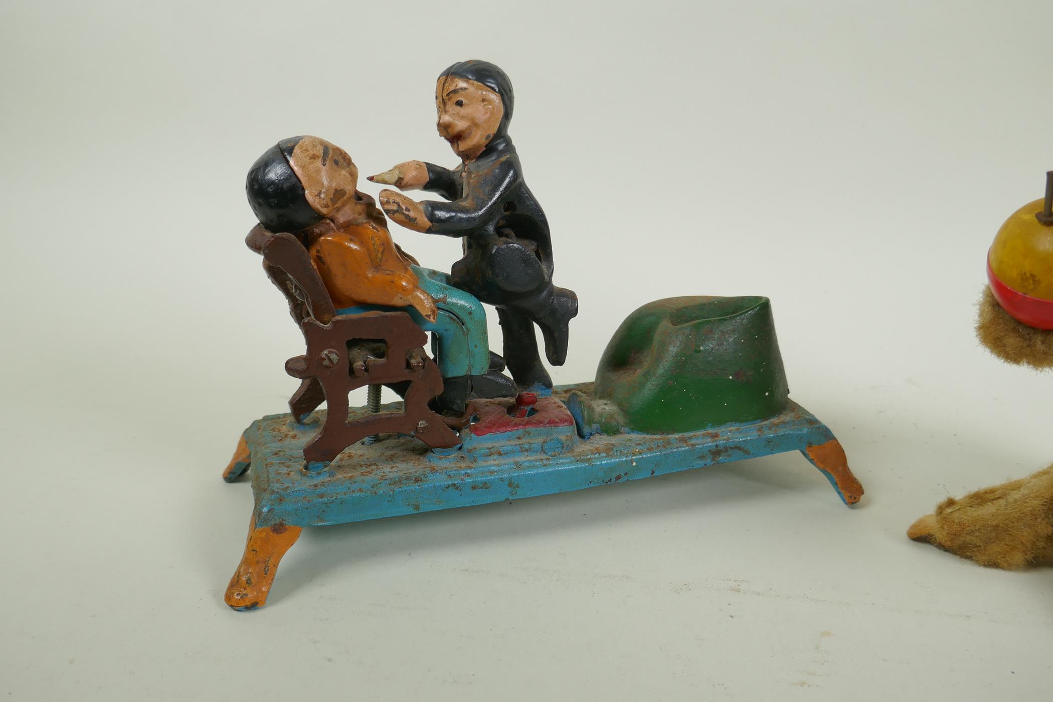 A painted cast iron money box in the form of a dentist, 22cm long, and a vintage clockwork money - Image 2 of 4