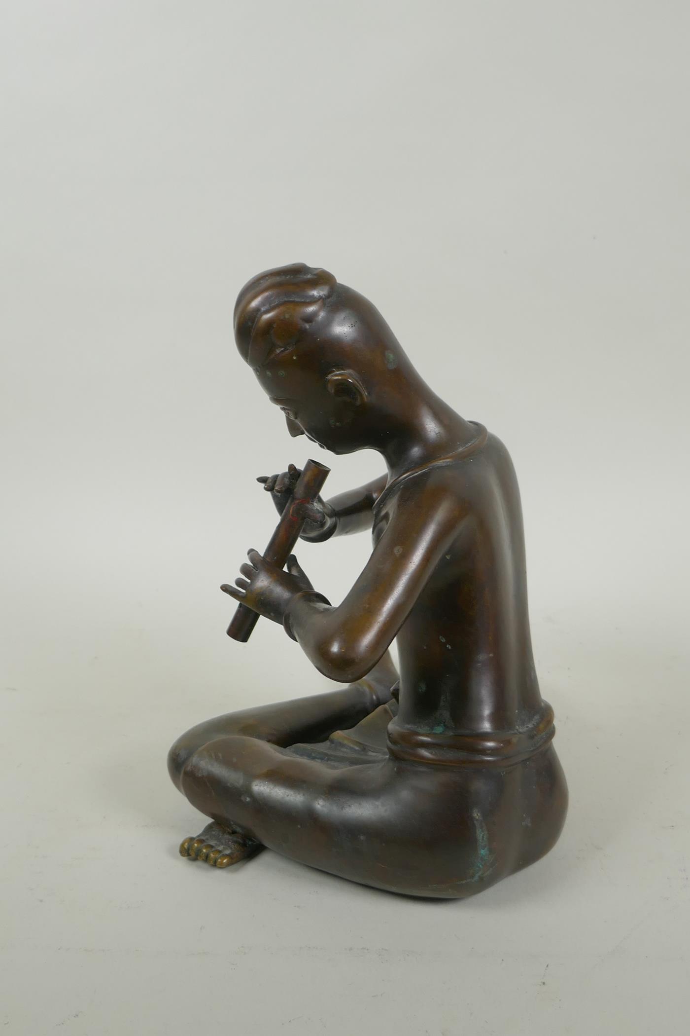A Thai filled bronze figure of a musician playing the flute, 23cm high - Image 2 of 4