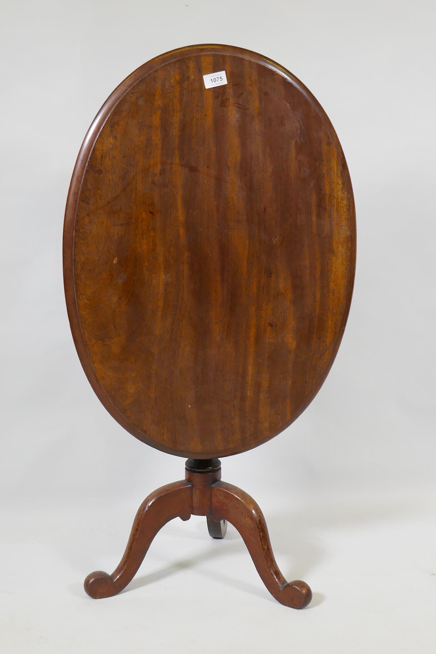 A Victorian mahogany tilt top occasional table, raised on turned column and tripod supports, 54 x 75