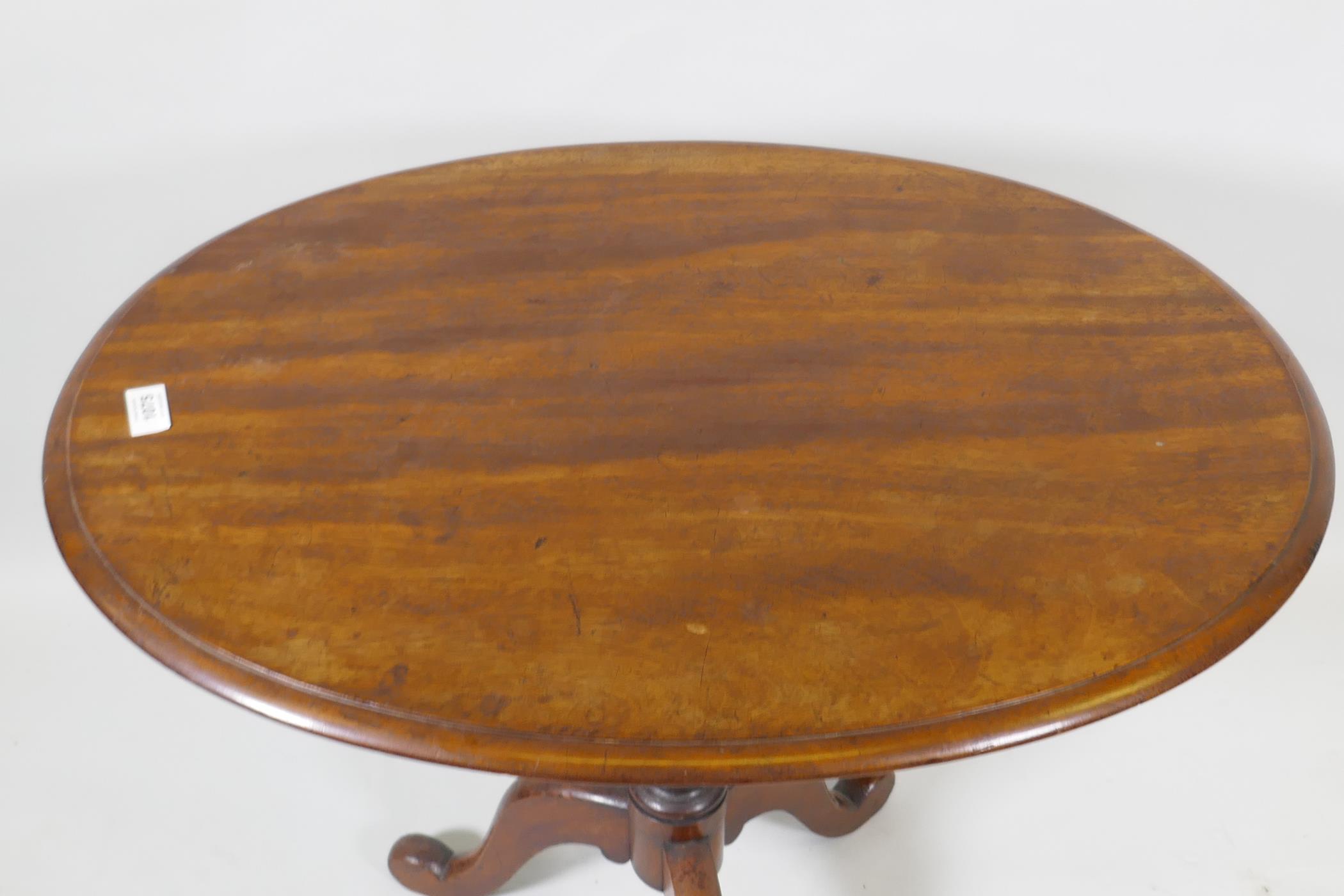 A Victorian mahogany tilt top occasional table, raised on turned column and tripod supports, 54 x 75 - Image 3 of 3