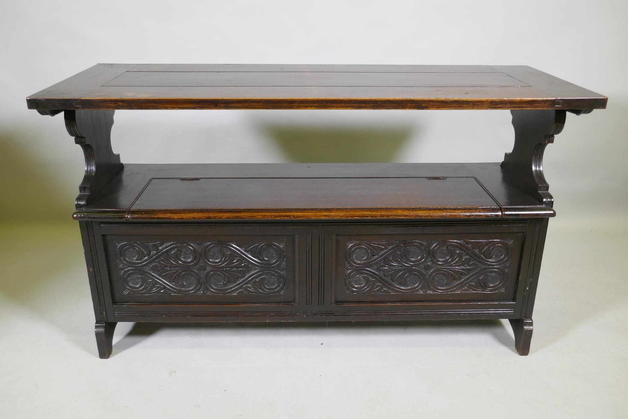 A Victorian oak monk's bench, with two panel fold over top, lift up seat and panelled front with - Image 3 of 3