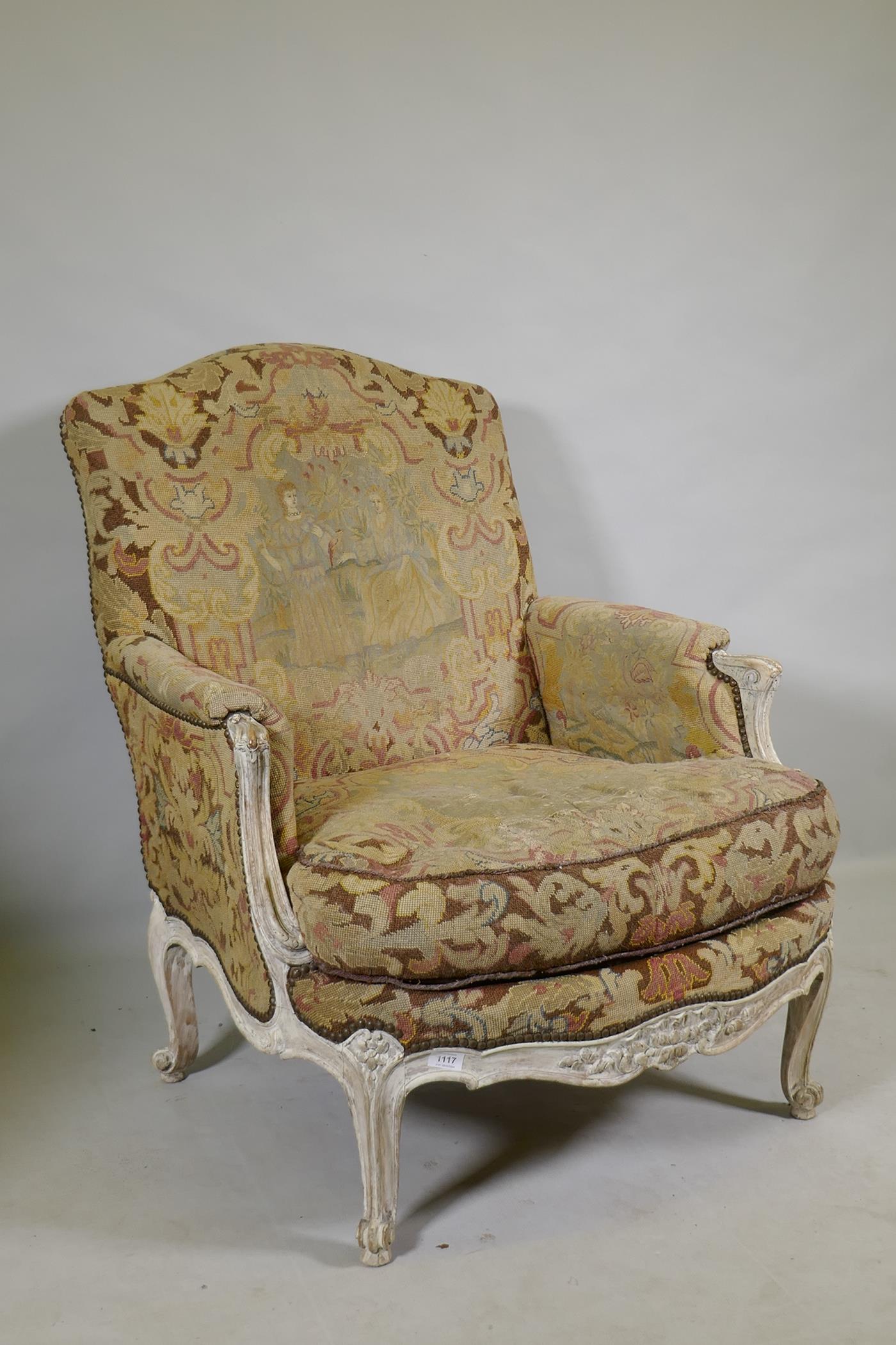 An C18th style French carved and painted beechwood framed arm chair with tapestry covers