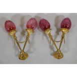 A pair of ormolu two branch wall lights with cranberry glass shades, 57cm long