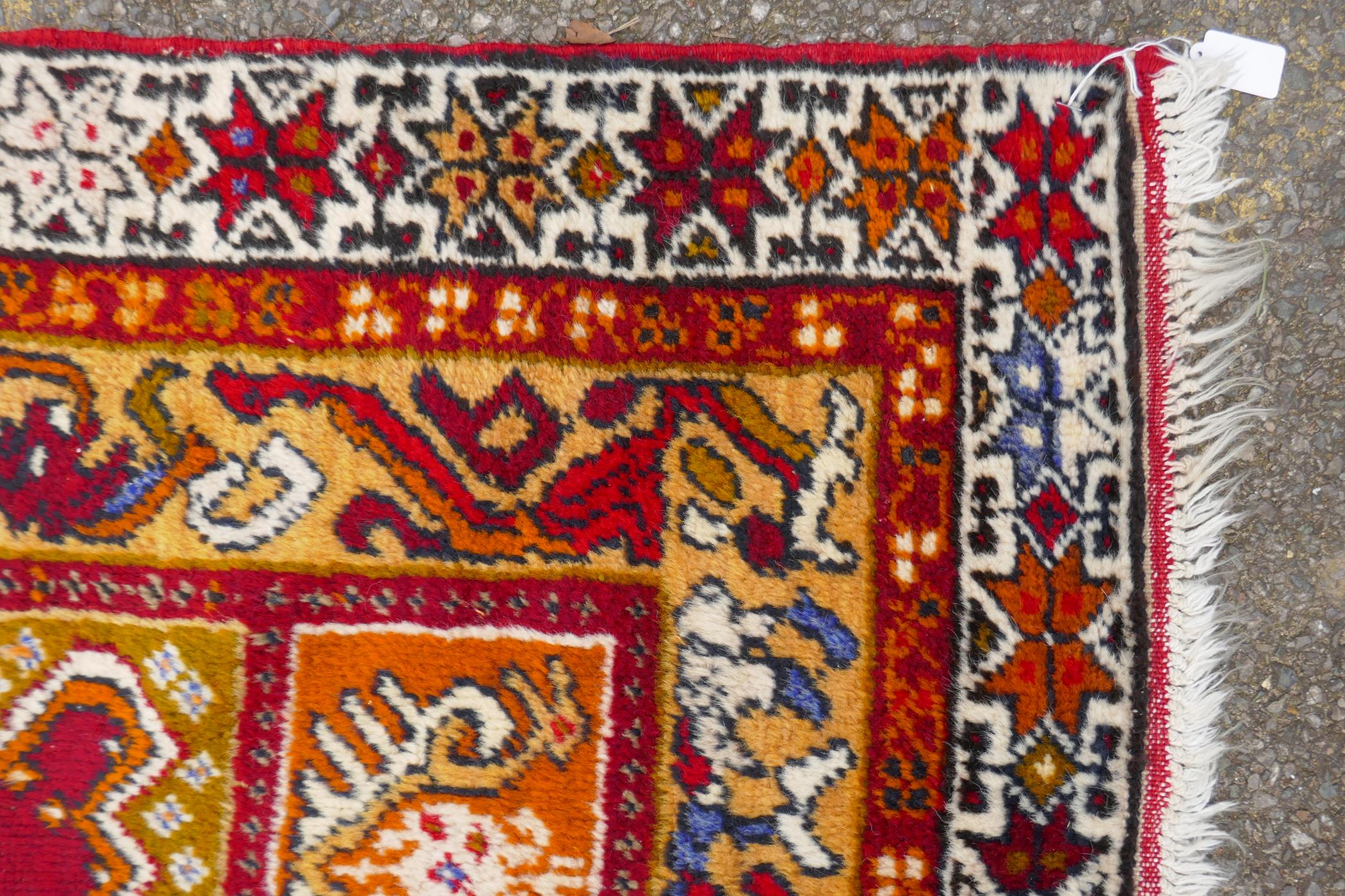 A rich red ground Caucasian rug with prayer mat design and multi-colour borders, 112 x 186cm - Image 2 of 3