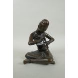 A Thai filled bronze figure of a musician playing the flute, 23cm high