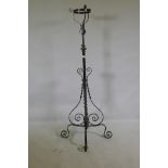 A Victorian wrought iron and brass telescopic standard lamp base with oil lamp basket, 140cm high,