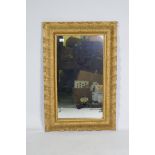 An antique carved giltwood framed wall mirror, 61 x 92cm