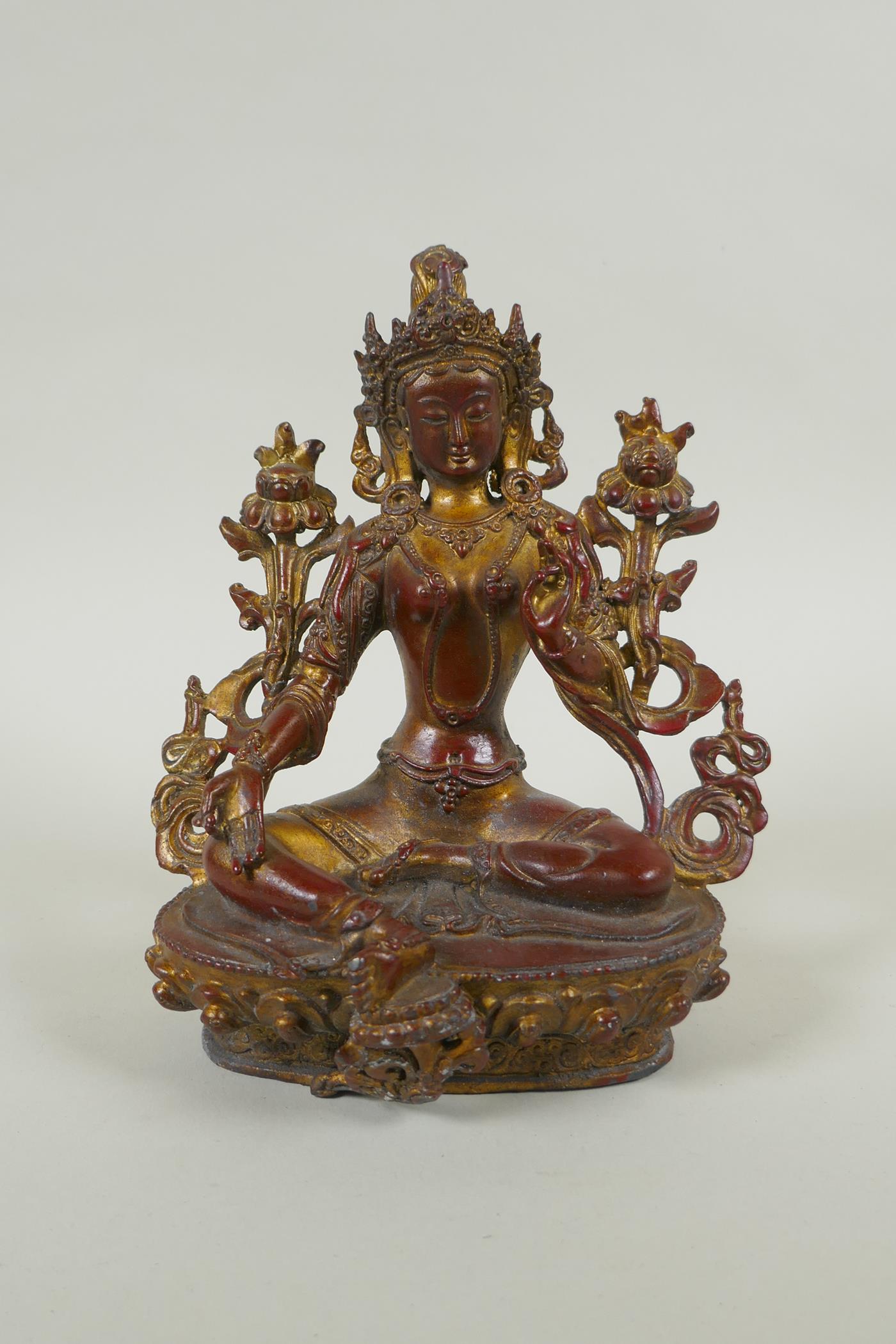 A Tibetan bronze figure of white tara with gilt and copper patina, 20cm high