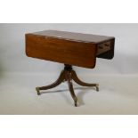 A Georgian mahogany pembroke table with one true and one false drawer, raised on a turned column and