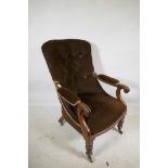 A Victorian mahogany framed open arm chair with button back and carved scroll arms, raised on turned